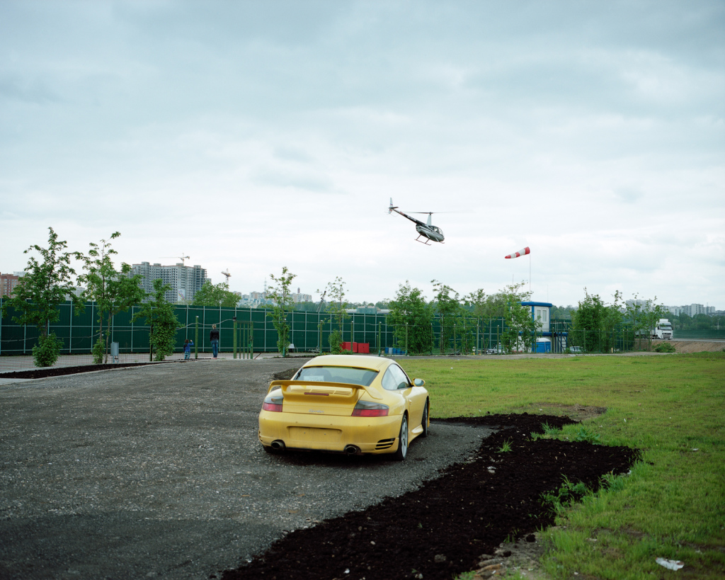Petr Antonov. Trees, cars, figures of people, assorted barriers (Plate 24: Нelipad c/w fence, windsock, rubbish bins, portable offices and toilet, helicopter during take off, trees, parking space c/w sports car, figures of people, lawn, truck)